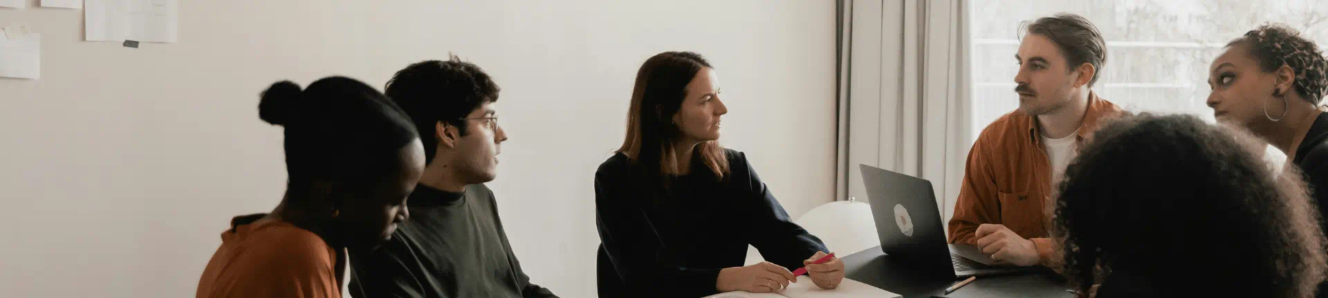 Team members seated at a table, actively collaborating on strategies for recruitment process outsourcing initiatives. Team members seated at a table, actively collaborating on strategies for recruitment process outsourcing initiatives.