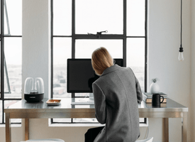 Woman in an office space in front of a computer Woman in an office space in front of a computer