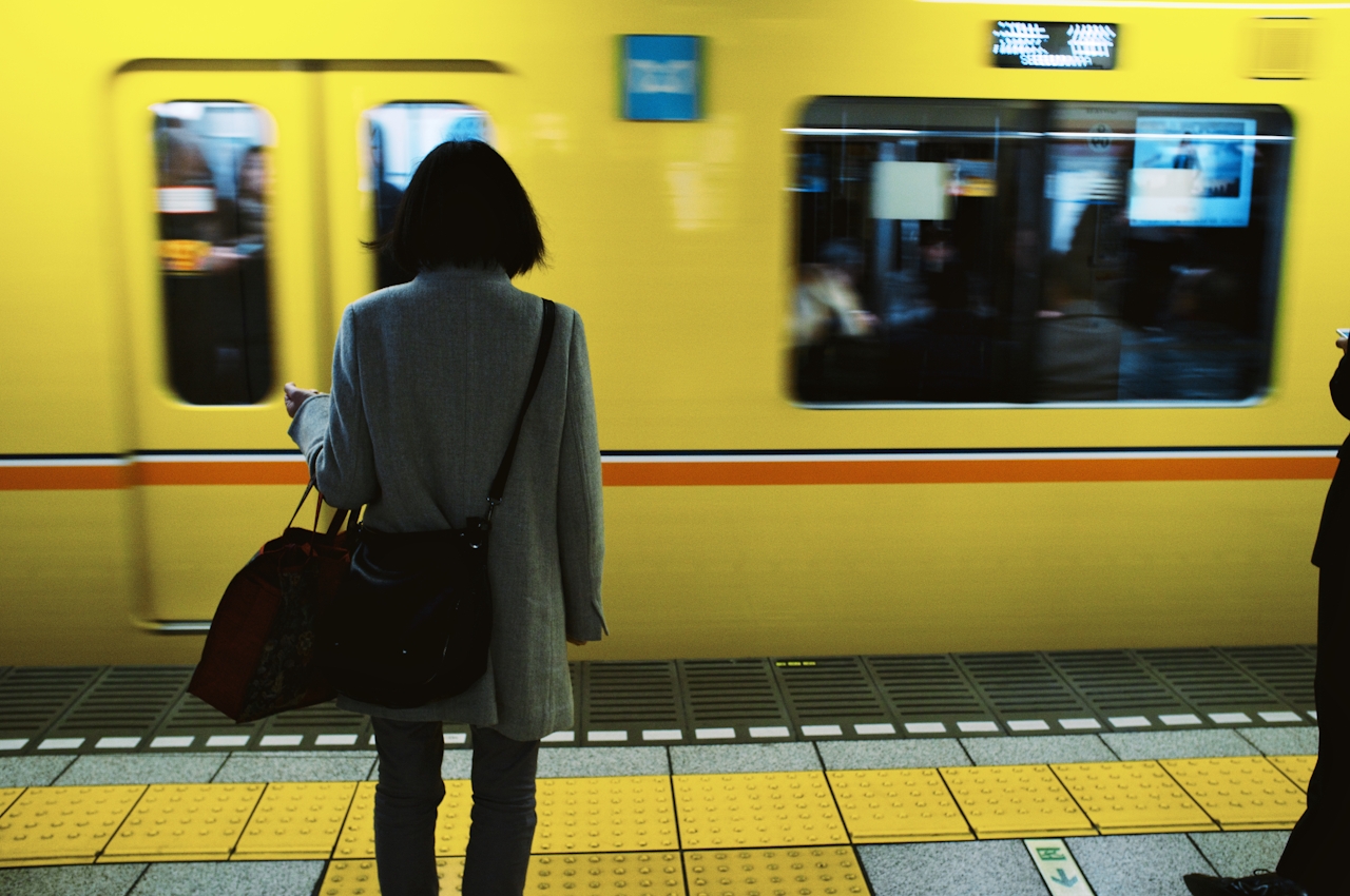 Lady waiting for a subway train representing the understanding of local connection to global business. Lady waiting for a subway train representing the understanding of local connection to global business.