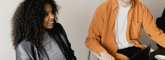 In a modern office, a woman and a man are seated together, with the woman positioned at the front and more prominently visible. In a modern office, a woman and a man are seated together, with the woman positioned at the front and more prominently visible.