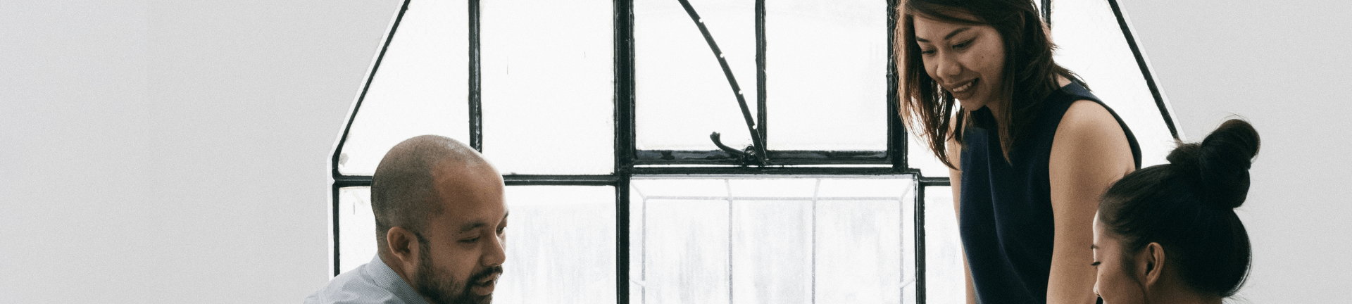 A man and woman engage in discussion at a table, utilizing a laptop to explore ideas related to total talent services.