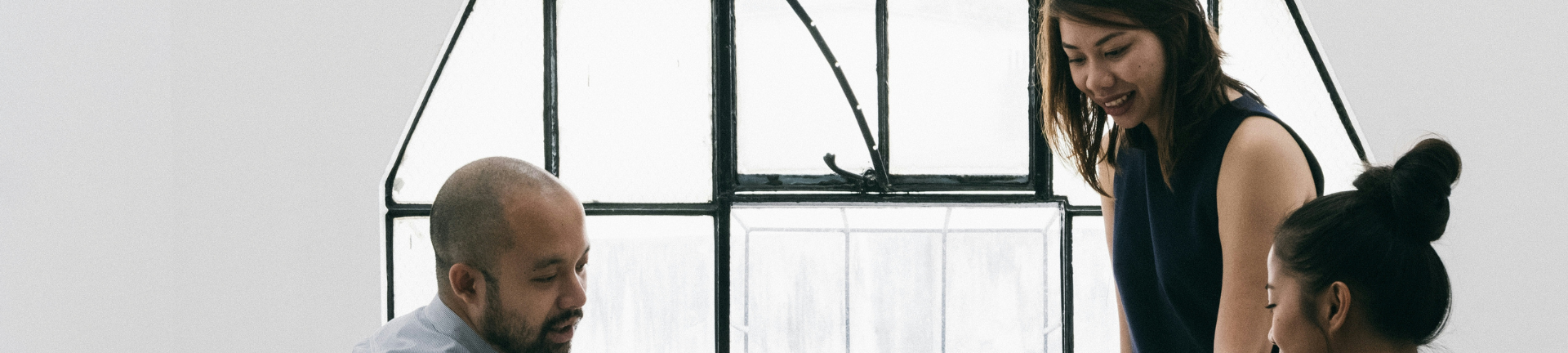 A man and woman engage in discussion at a table, utilizing a laptop to explore ideas related to total talent services. A man and woman engage in discussion at a table, utilizing a laptop to explore ideas related to total talent services.